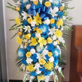 Standing floral spray with blue, yellow, and white flowers on an easel