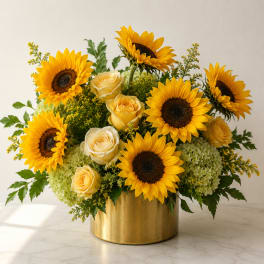 Sunflowers and cream roses arranged in a gold vase