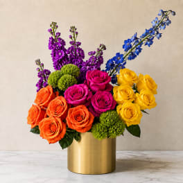 Colorful bouquet of roses and purple-blue flowers in a gold vase
