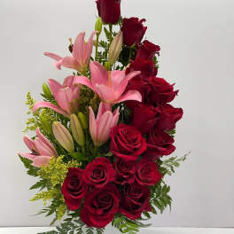 Red roses and pink lilies arranged in a white vase