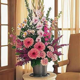 Tall pink floral arrangement with gerbera daisies and carnations in a gray pot