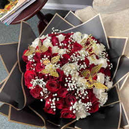 Bouquet of red and white roses with gold butterfly accents