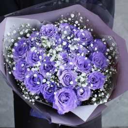Bouquet of purple roses with white baby's breath in lavender wrap