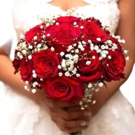 Bride holding a bouquet of red roses with baby's breath