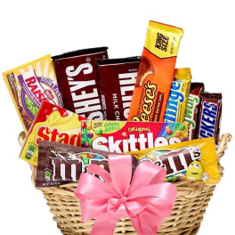 Basket of assorted candy bars and sweets tied with a pink ribbon