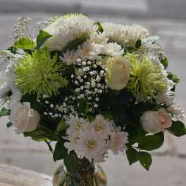 White and pale green bouquet in a glass vase