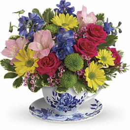 Colorful bouquet in a blue-and-white teacup and saucer