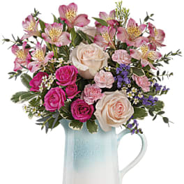 Pink and cream roses with alstroemeria in a blue ceramic pitcher