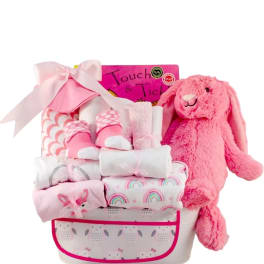 Pink gift basket with a plush bunny and wrapped baby items