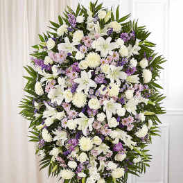 Large standing spray of white and lavender flowers on an easel