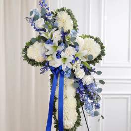 White and blue funeral spray with ribbon on an easel