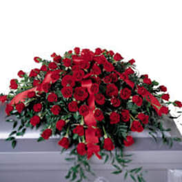 Large red rose casket spray with ribbon accents