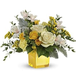 Yellow and white rose arrangement in a square yellow vase