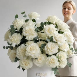 Large white rose arrangement in a white hat box with eucalyptus