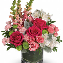 Pink roses and white alstroemeria in a clear square vase