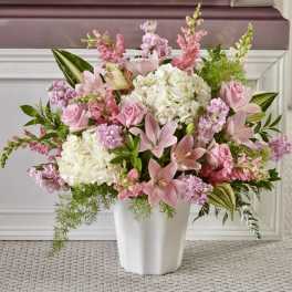 Large pink and white arrangement with lilies, roses, and hydrangeas in a white vase