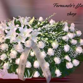 Large white lily and rose casket spray with memorial ribbons