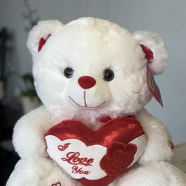 White teddy bear holding a red heart that says I Love You