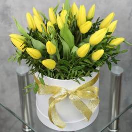 Yellow tulips in a white hatbox tied with a gold ribbon