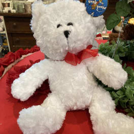 White plush teddy bear with a red ribbon bow