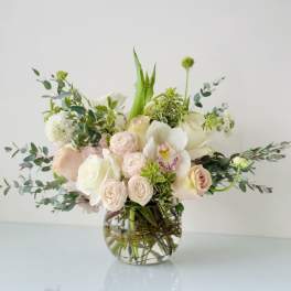 Blush and white floral arrangement in a clear glass vase