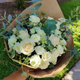Bouquet of white roses with eucalyptus wrapped in brown paper