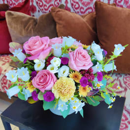 Pink roses and mixed pastel flowers arranged in a white vase