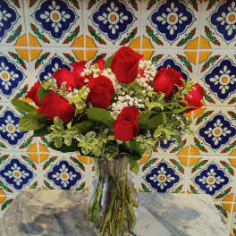 Red roses arranged in a clear glass vase