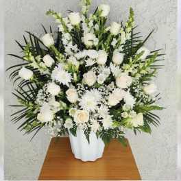 White roses and daisies arranged in a white vase