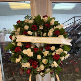 Heart-shaped wreath of red and white roses on a stand