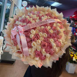 Large bouquet of pink and cream roses with a pink ribbon
