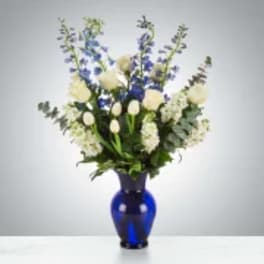 Blue and white floral arrangement in a cobalt glass vase