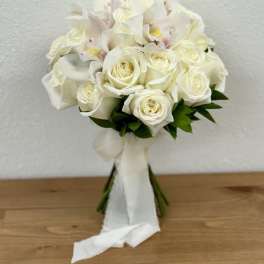 White rose and orchid bouquet with a white ribbon wrap