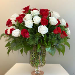 Red and white roses arranged in a clear glass vase