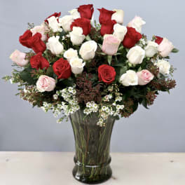 Bouquet of red, white, and pink roses in a glass vase