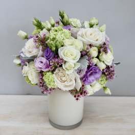 White and lavender rose bouquet in a glass vase