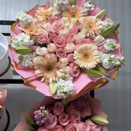 Pink and peach bouquet with roses, gerbera daisies, and lily buds