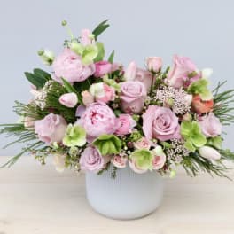 Pink and green floral arrangement in a white vase