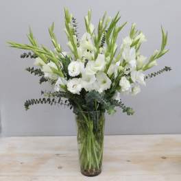 White gladiolus and lisianthus in a clear glass vase