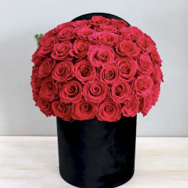 Round bouquet of bright pink roses in a black box