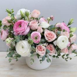Pink and white roses with ranunculus in a white vase