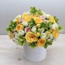Bouquet of yellow, white, and pink roses in a white vase