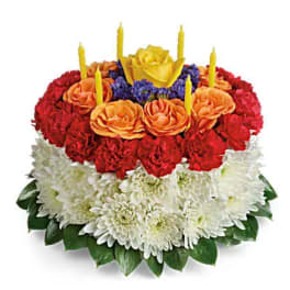 Round floral cake with candles in red, orange, yellow, and white flowers