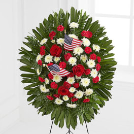 Standing floral wreath with red and white flowers and small American flags