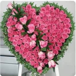 Heart-shaped arrangement of pink roses on a stand