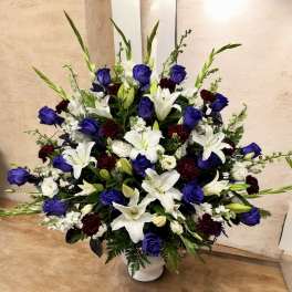 Large white and blue floral arrangement in a white vase