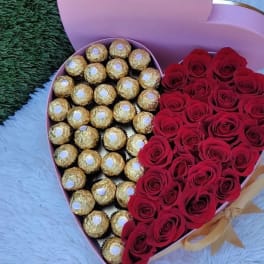 Heart-shaped box with red roses and gold-wrapped chocolates