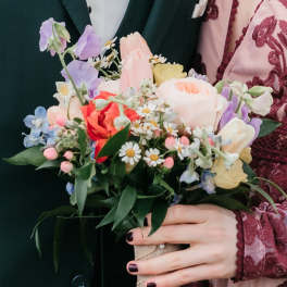 Hand-tied bouquet of pastel flowers with a burlap wrap
