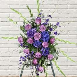 Tall purple and lavender floral arrangement with roses and blue blooms