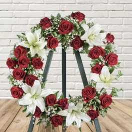 Red rose and white lily wreath on a stand
